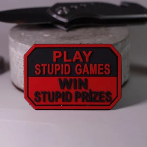 PVC guminis antsiuvas play stupid games win stupid prizes raudonas